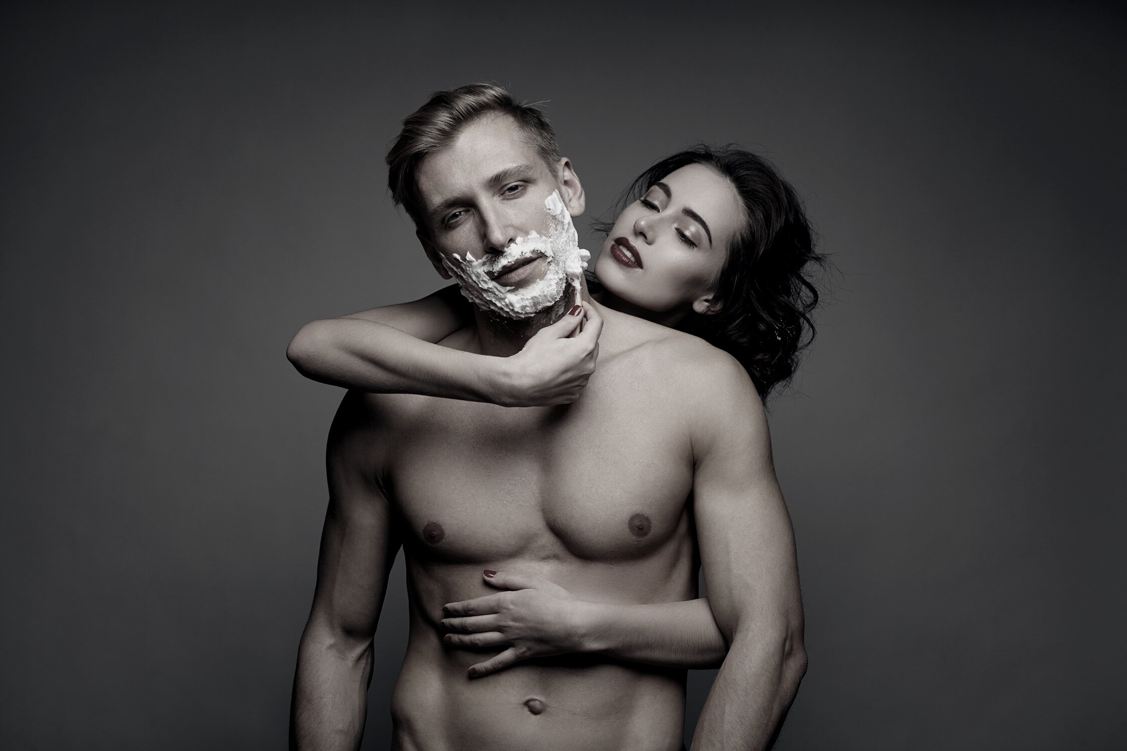 Woman shaving male sensually